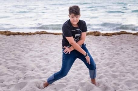 Teenager übt dance moves am Strand